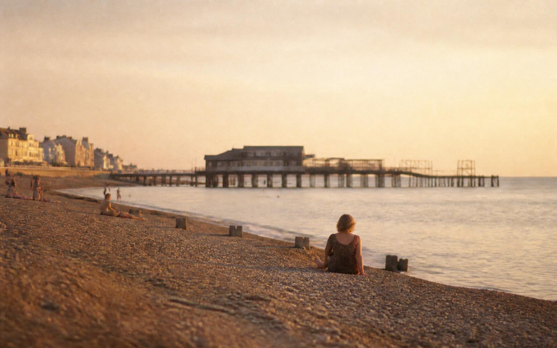 Deal seafront on an August evening, the wooden pier silhouetted against a hazy golden sky above a calm sea and shingle beach